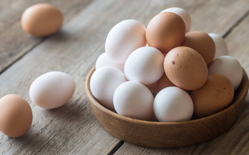 Wooden bowl of raw chicken eggs